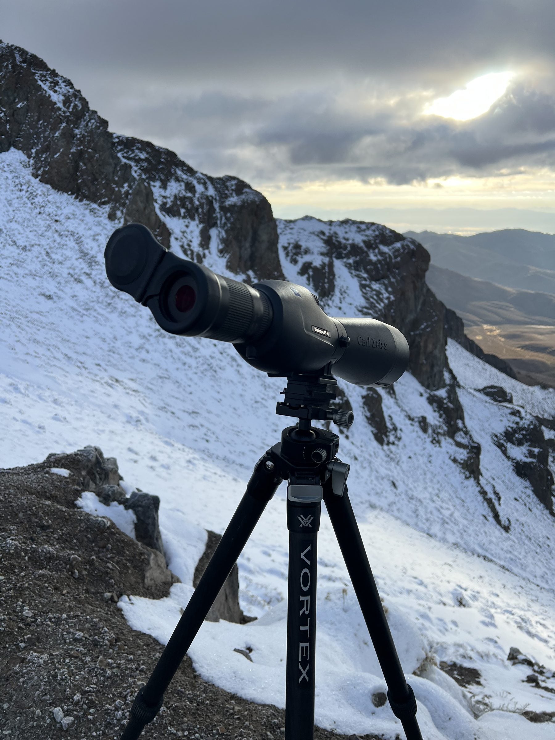Hunter glassing a basin at sunset with a MagRac-mounted spotting scope